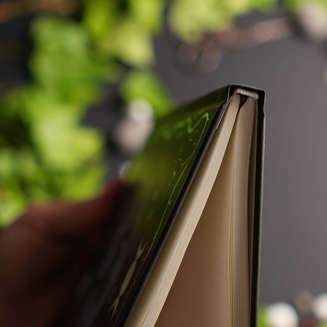 Close-up of the hardcover binding showing the durable casebound construction and thick cream-colored pages.