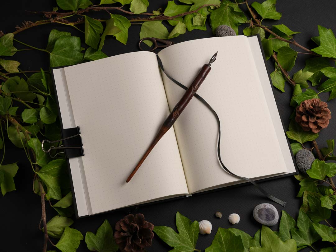 Open A5 hardcover notebook with dot grid pages, ribbon bookmark, and premium 100 gsm Munken Pure paper.