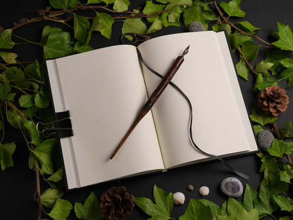 Open A5 hardcover notebook with dot grid pages, ribbon bookmark, and premium 100 gsm Munken Pure paper.