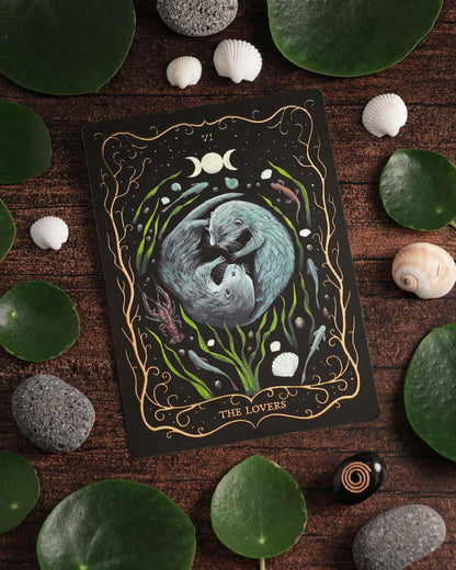 Hand-painted A6 Tarot postcard "The Lovers" with shimmering gold foil, displayed with botanical and seaside-inspired styling.