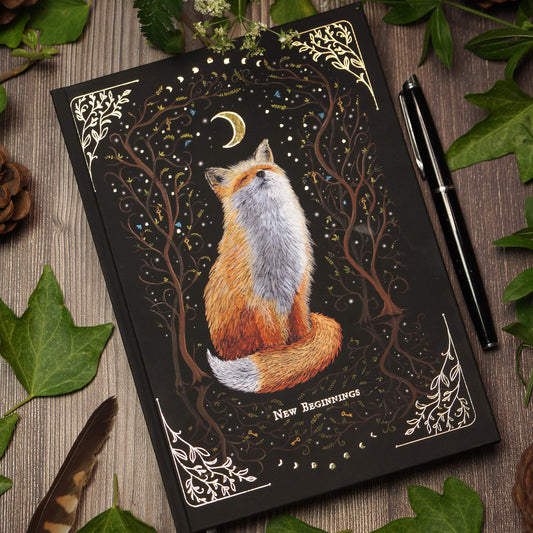 Witchy notebook "New Beginnings" with hand-painted fox illustration, gold foil moon phases and stars on black hardcover, A5 journal with Munken Pure paper.