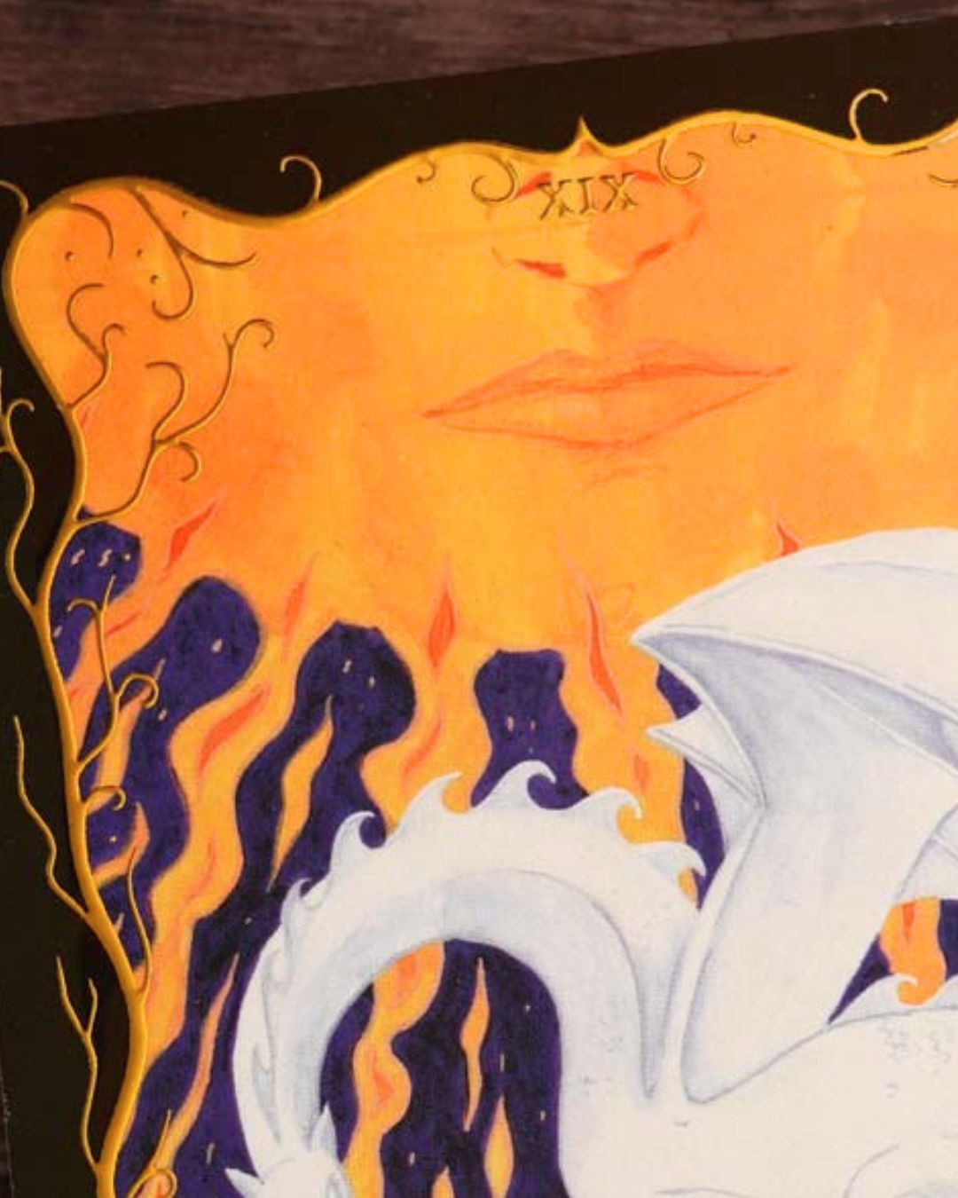 Close-up of the glowing sun and gold foil border on The Sun Tarot postcard.
