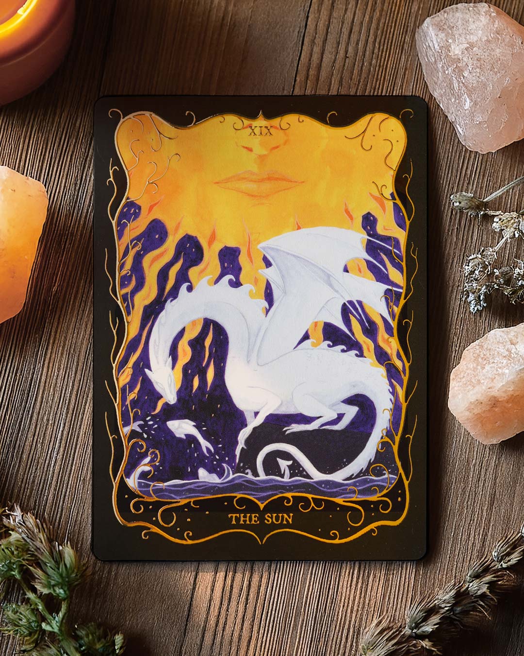 The Sun Tarot postcard displayed with crystals and dried flowers, highlighting the hand-painted fantasy artwork.