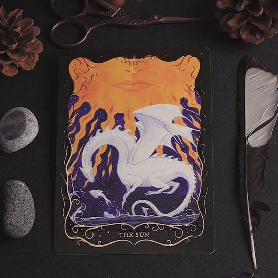 Video showing The Sun Tarot postcard with shimmering gold foil details as the card is gently moved to catch the light.