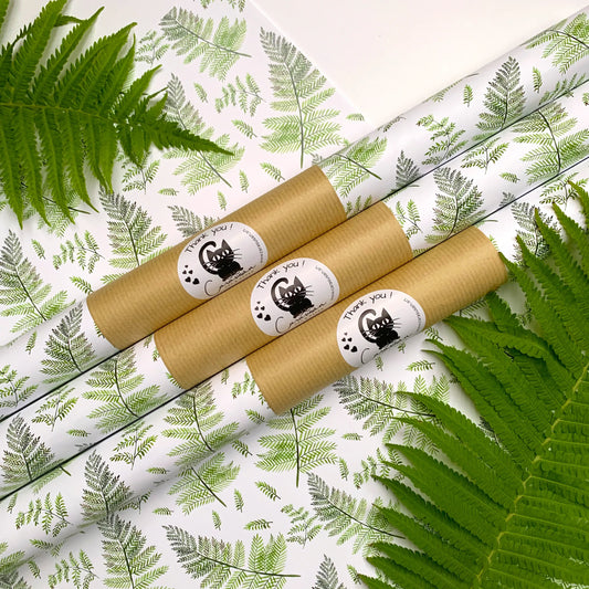 Botanisches Geschenkpapier mit grünen Aquarell-Farnen auf weißem Grund, dekoriert mit Farnblättern und drei gerollten Papierbögen